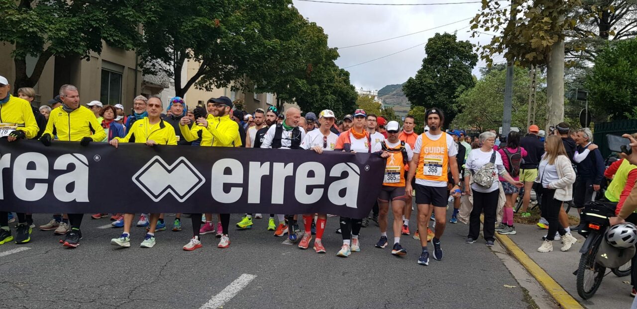 Le cortège avec la banderolle tenue par Hervé, Nicolas et leurs guides au premier rang, en route pour le départ des 100km de Millau